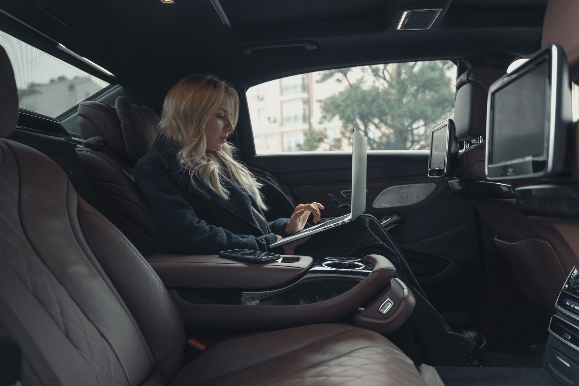 Principal working in the back of a chauffeured executive vehicle